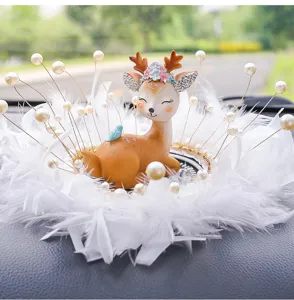 Cute deer car ornament with white feather base and pearl decorations on dashboard