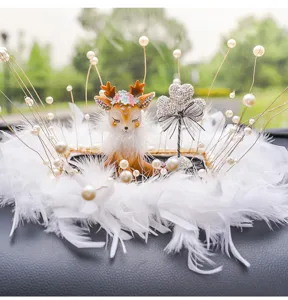 Detailed close-up of a cute deer car ornament with white feathers and pearl accents