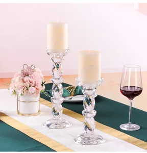 Two elegant faceted crystal glass candle holders set on a romantic wedding dinner table