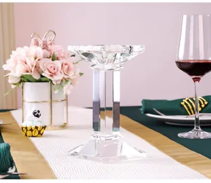 Detalle de un portavelas de cristal tallado en una elegante mesa de comedor de boda