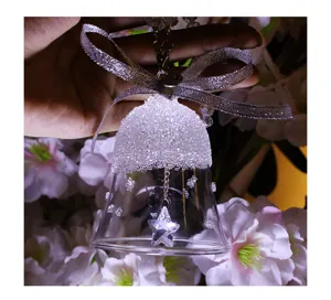 Detailed macro shot of clear K9 crystal bell ornament with silver bow and star pendant