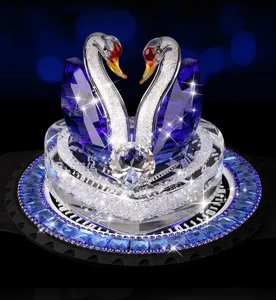 Dettaglio ornamento auto cigno di cristallo con ali in strass blu e base sfaccettata lucida.