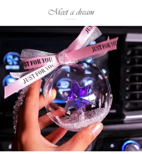 Close-up view of a crystal car hanging ornament with a purple faceted star inside