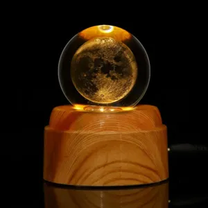 Detalle del grabado láser 3D de la luna en bola de cristal sobre base de madera con LED
