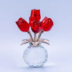 Close-up detail shot of red crystal rose flowers with shiny silver stems and a clear faceted vase.