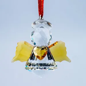 Detailed view of a faceted crystal angel suncatcher with a yellow heart and golden wings