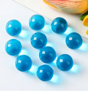 Detailansicht von lichtdurchlässigen blauen Glasmurmeln auf weißem Grund
