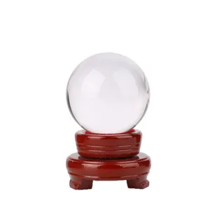 Heldere transparante kristallen bol decoratie met een donkerrode houten standaard voor huis