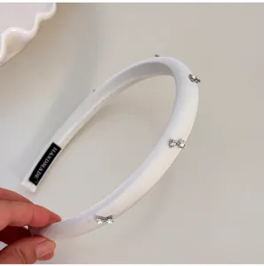 Primer plano de una diadema de esponja blanca con delicados lazos de pedrería