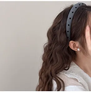 Vue détaillée d'un bandeau gris à pois élégant pour rehausser le profil des cheveux longs.