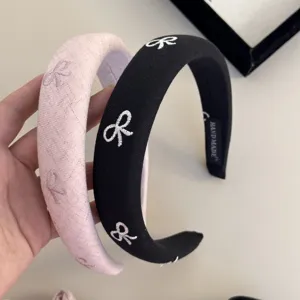Set di cerchietti imbottiti rosa e neri con graziosi ricami a fiocco bianchi e morbidi