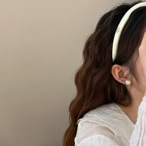 Serre-tête élégant en satin crème de style français avec un petit emblème doré.