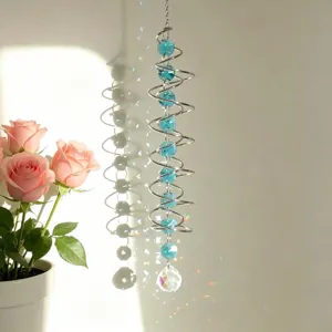 Blue spiral crystal suncatcher wind chime hanging near window with rainbow refractions
