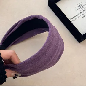 Gros plan d'un serre-tête en tricot violet doux montrant la texture délicate du tissu.