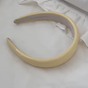 Detailed close-up of a cream faux leather padded headband with high cranium French style design
