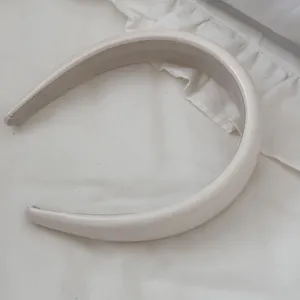 Macro view of minimalist cream faux leather padded headband with soft sponge texture