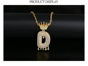 Detail van een hiphop iced-out letter D hanger met gouden kroon op een gedraaide touwketting.