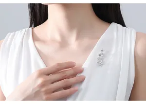 Élégante broche fleur scintillante en argent sur robe blanche pour un style raffiné