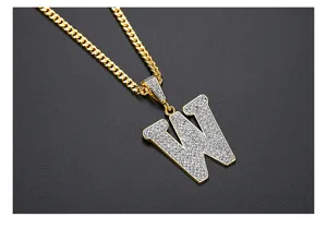 Vista detallada de un colgante de letra W con pavé de CZ en una cadena cubana de oro