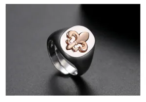 Detailed close-up of a retro two-tone metal signet ring with a rose gold fleur-de-lis.