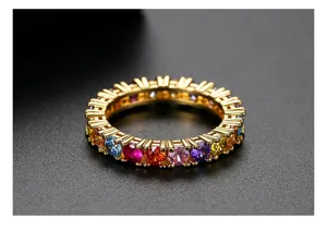 Close-up van een goudkleurige eternity ring met kleurrijke regenboog zirkonia steentjes.
