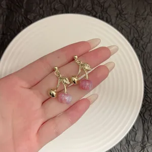 Detailed view of sweet cherry stud earrings featuring pink glitter beads and gold stems