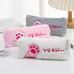 Close-up detail of cute plush pencil cases featuring pink paw embroidery and soft fuzzy texture