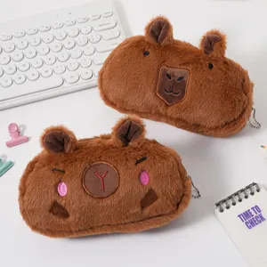 Adorable plush capybara pencil cases with cute faces on a white desk with keyboard