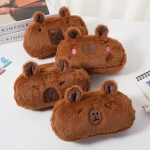 Detailed view of four different cute capybara plush pencil cases on a white desk.