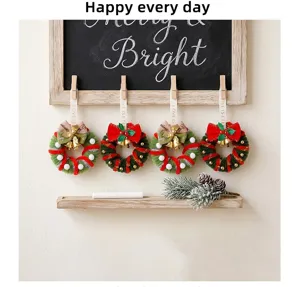 Set of 4 mini Christmas wreaths with bells and bows hanging on a chalkboard