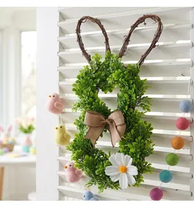 Easter bunny wreath with boxwood leaves, grapevine ears, and burlap bow on white shutters