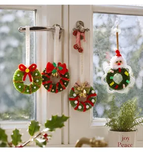 Assorted mini Christmas wreaths hanging on a window for festive holiday decoration
