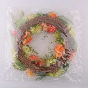 Decorative Christmas floral wreath packaged in clear plastic bag showing vine and leaves