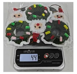 Weight measurement of three Christmas mini wreaths on a digital scale showing 44g