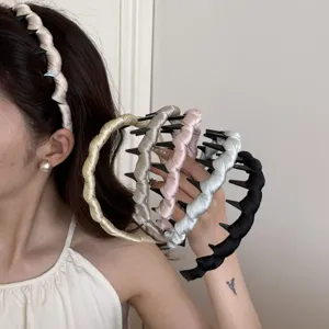 Close-up detail of satin-wrapped wavy hair hoops with teeth in various pastel colors