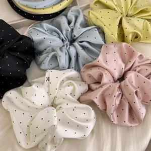 Vue détaillée de chouchous en satin à pois assortis avec un éclat de soie élégant et motifs
