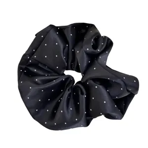 Chouchou en satin noir à pois blancs pour coiffures élégantes en queue de cheval ou chignon