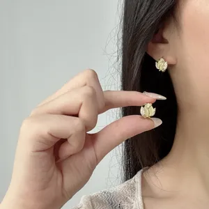 Primer plano de elegantes pendientes de tulipán con piedra ojo de gato y cristales