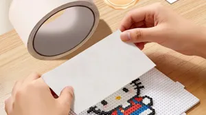 Brede schilderstape gebruikt als strijkhulpmiddel voor strijkparels DIY-projecten.