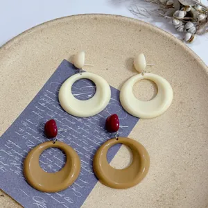Close-up view of French vintage geometric round resin earrings in cream and caramel