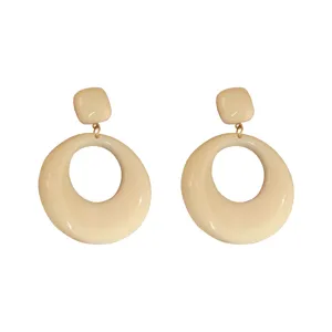 Detail view showing the thick resin finish of retro cream geometric round earrings