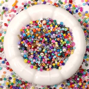 Mixed colorful glass seed beads and tube beads 2-4mm for DIY jewelry making in a white bowl.