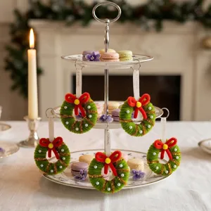 Set of 5 mini green Christmas wreath ornaments with red bows on a tiered serving stand