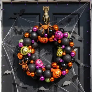 Ghirlanda di Halloween spettrale con palline arancioni e nere, zucche e ragni sulla porta