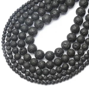 Close-up detail of porous black lava stone beads in various sizes for DIY jewelry