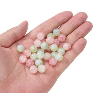 Main montrant la taille de perles en verre craquelé de 10 mm pour la création de bijoux