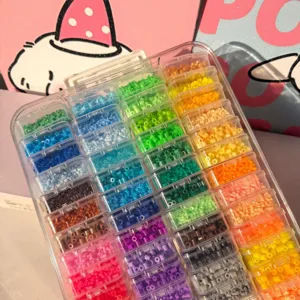 Große transparente Aufbewahrungsbox mit Regenbogen-Perlen in einzelnen kleinen Fächern