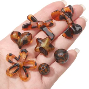 Nahaufnahme von Acrylperlen mit Leopardenmuster in verschiedenen Formen für DIY-Schmuck