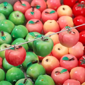 Detalle macro de dijes de manzana de resina brillante para hacer joyas artesanales