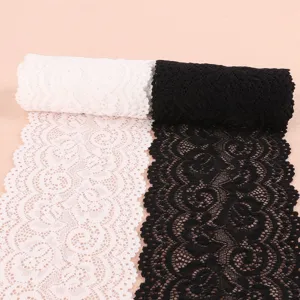 Detailansicht der elastischen Spitzenborte in Schwarz und Weiß mit zarten Blumenmustern.
